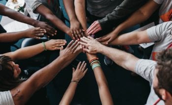 Group of people putting hands in the middle